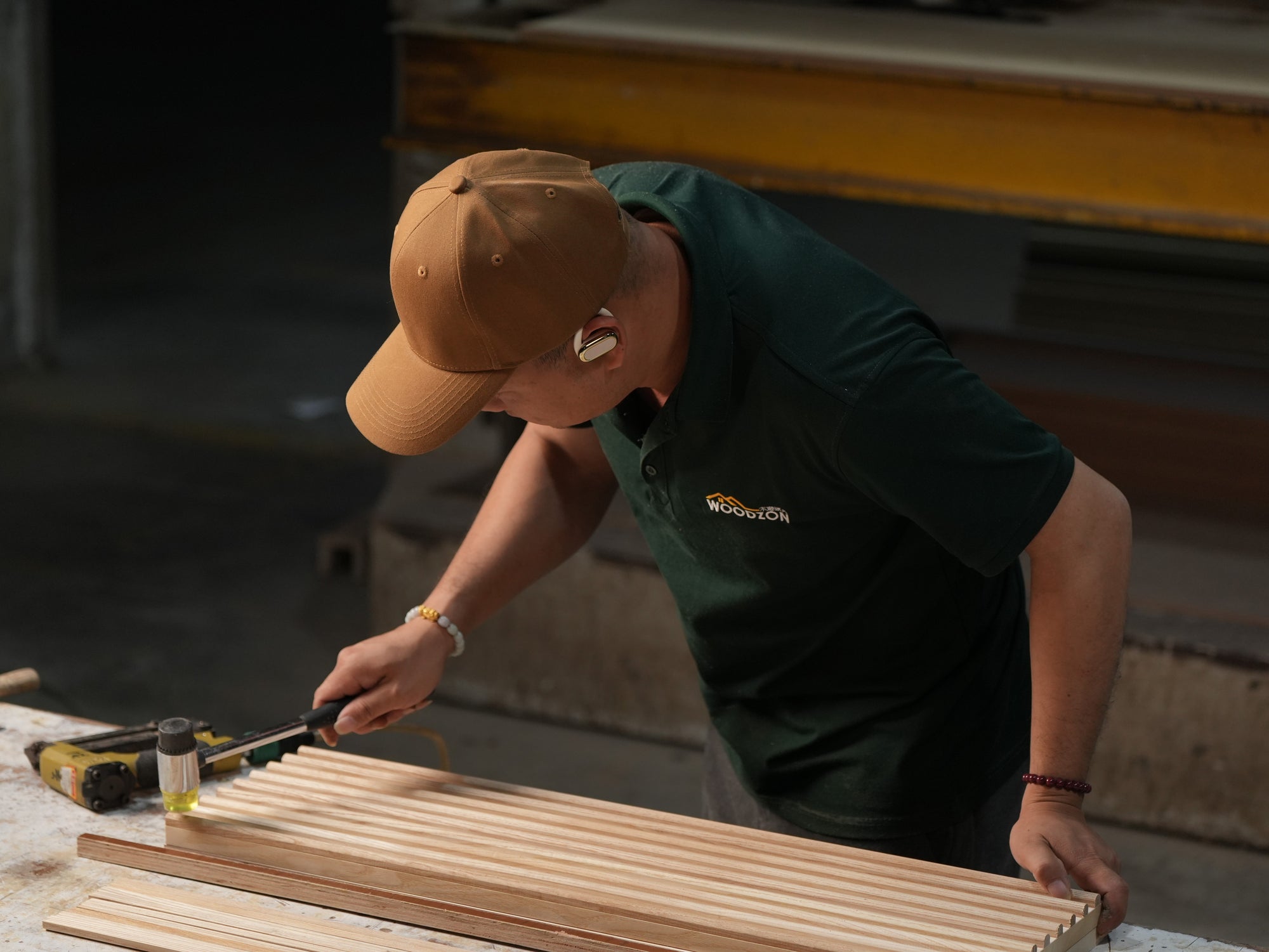 Person working with wooden planks and tools in a workshop setting